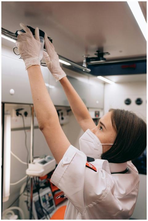 Paramedic adjusting equipment inside an ambulance,