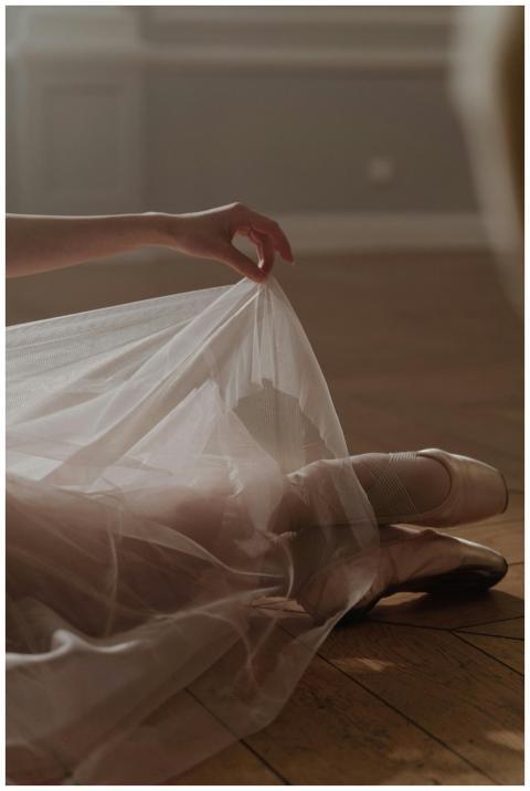 Graceful ballerina holding a delicate veil over po