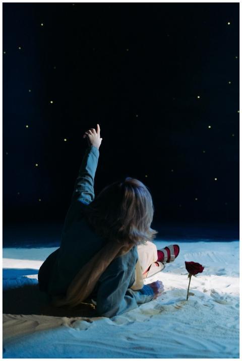 A child dressed in cosplay points at stars in a ni