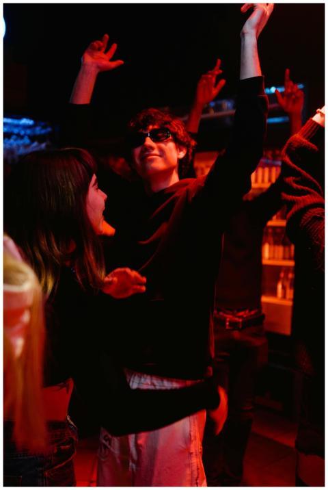 Group of friends dancing together indoors at a vib