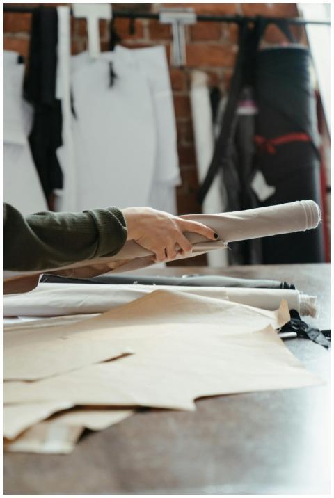 A close-up of hands holding fabric rolls in an org