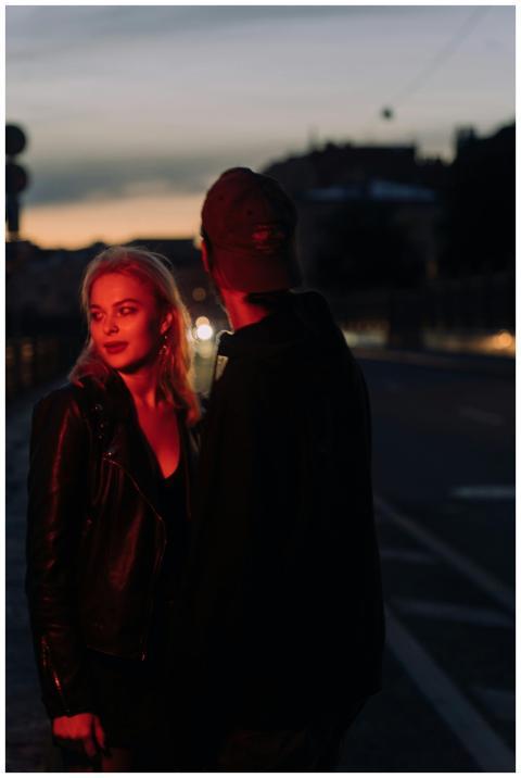 A couple sharing a moment on a dimly lit street at