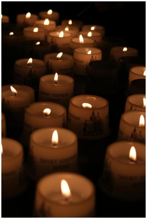 Rows of lit candles create a serene, warm atmosphe