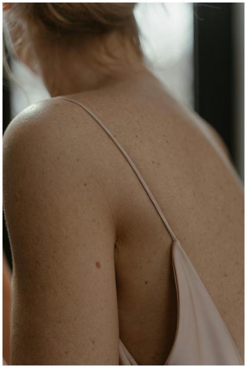 Close-up of a woman's freckled back in soft natura