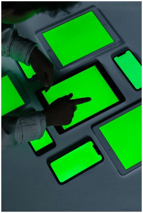 Person interacts with various green screen tablets