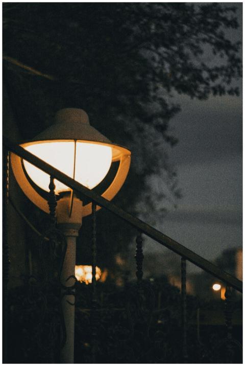 A vintage lamppost illuminating the dark surroundi