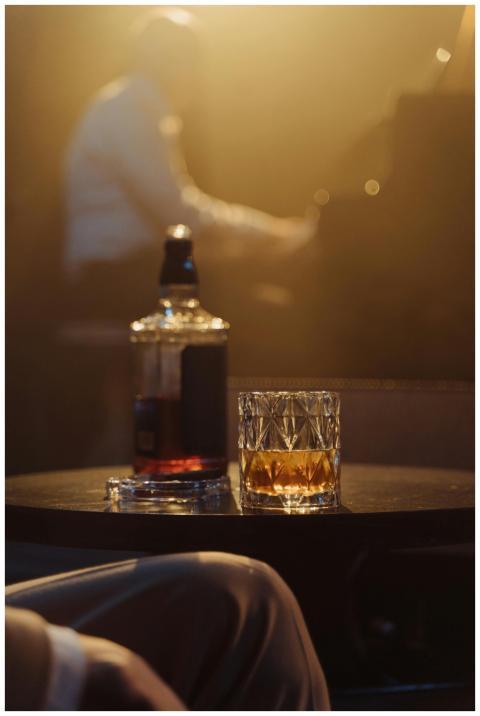 A cozy lounge scene with whiskey glass and blurred