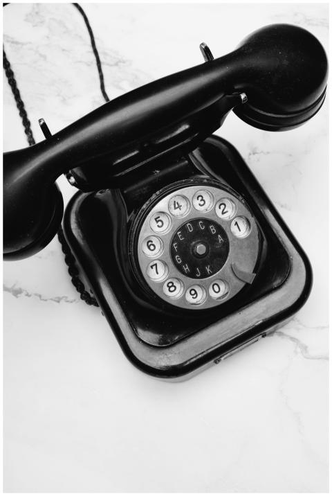 Classic black rotary phone displayed on a marble s