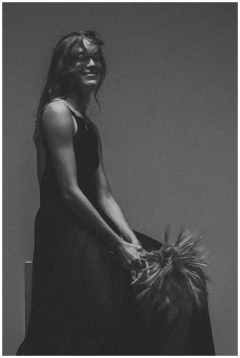 Graceful woman in a black dress smiling in a monoc