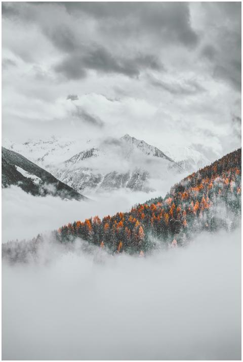 A breathtaking view of snow capped mountains and f