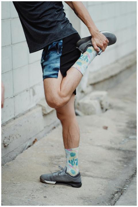 Man stretching leg in colorful socks and athletic