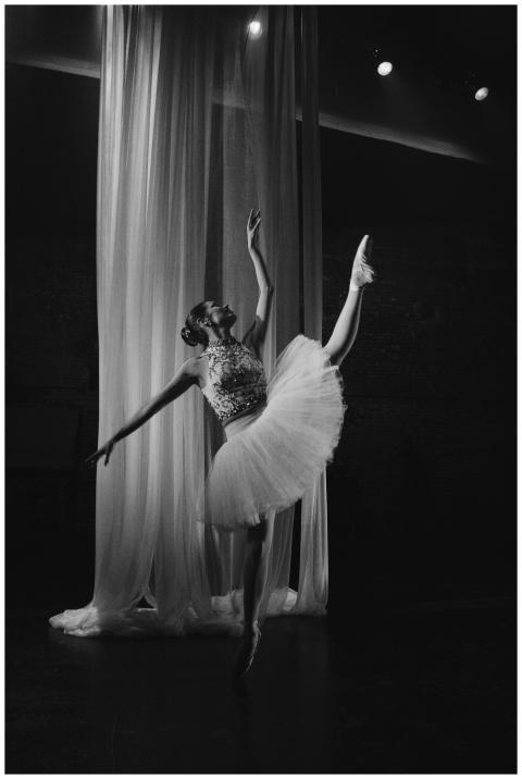 Graceful ballet dancer posing in a dramatic black