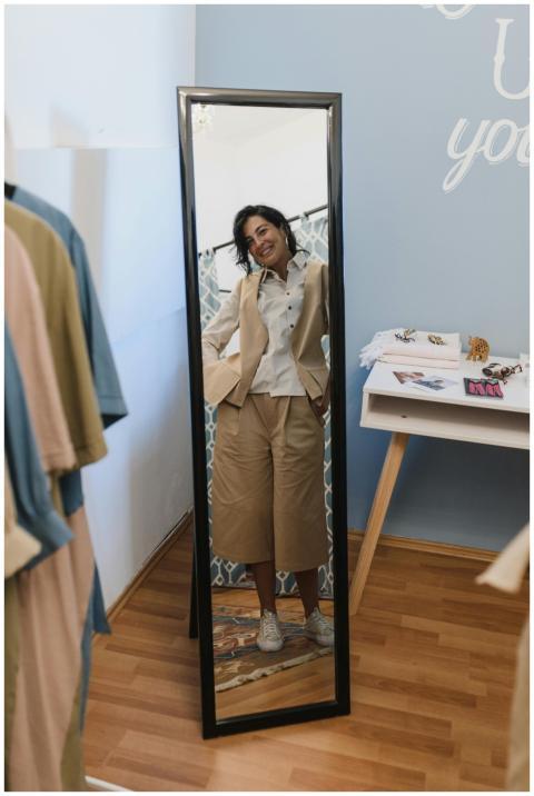 Stylish woman smiling at her reflection in a cloth