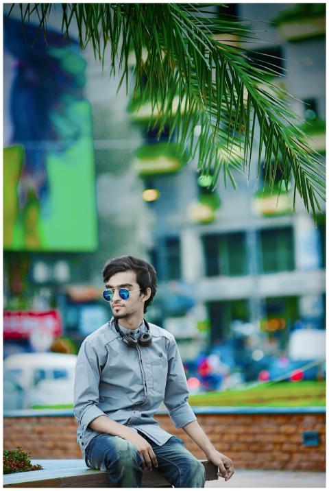 Stylish young man sitting in a vibrant urban park,