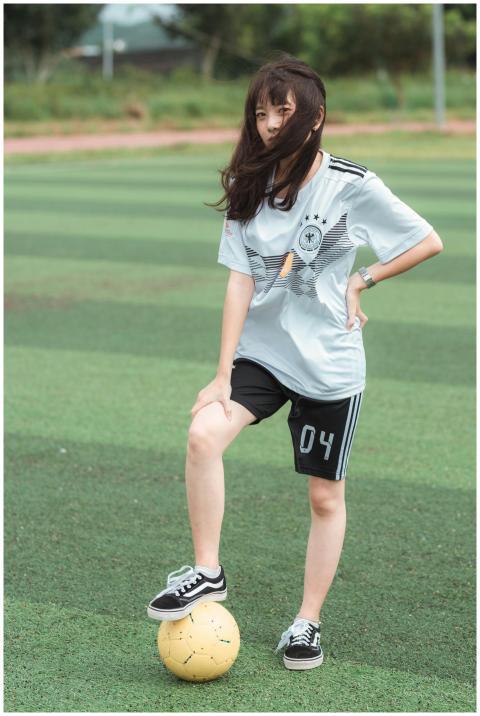 Teen girl in sportswear with a soccer ball on a fi