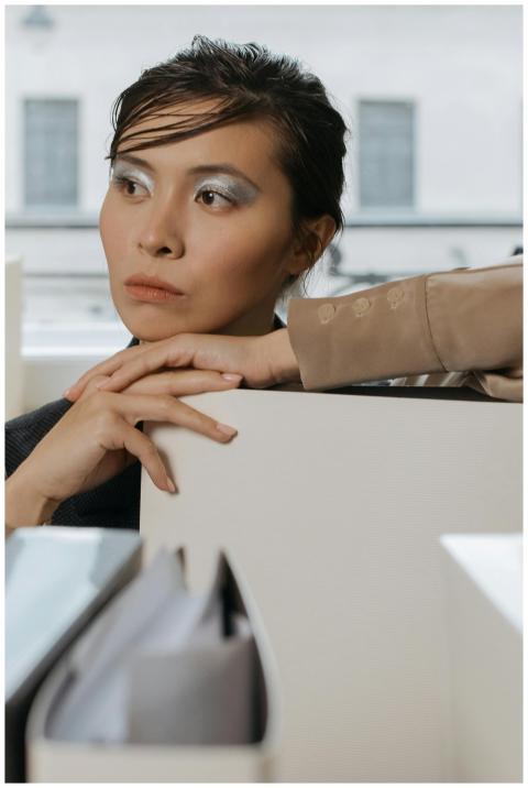Contemplative Asian woman in an office environment