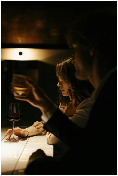 Couple enjoying drinks at a cozy bar, creating an