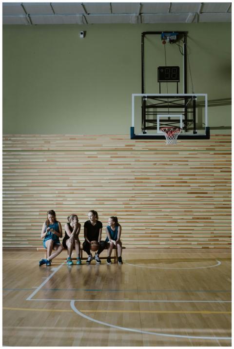 Group of young female basketball players sitting o