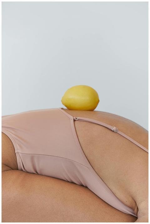 A creative shot of a lemon placed on a person's ba