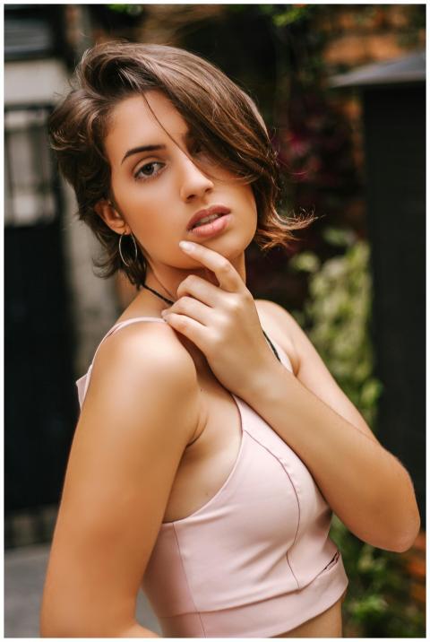Stylish young woman in a pink top posing confident
