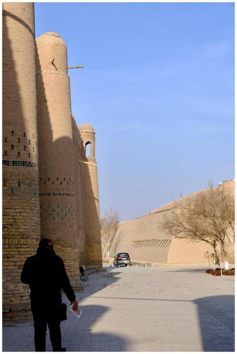 A person walks near the historic mudbrick walls of