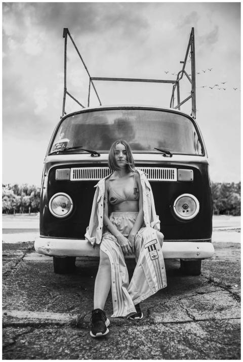 Stylish woman poses in front of a classic Volkswag