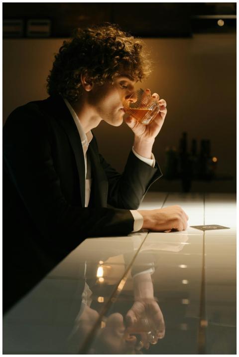 Elegant man in a bar enjoying a drink, reflecting