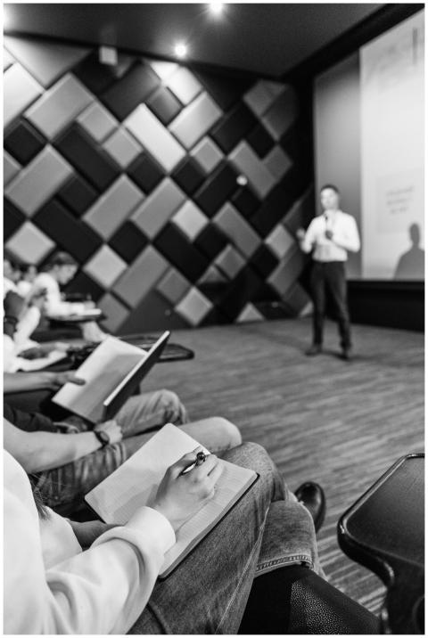 Black and white shot of students taking notes duri