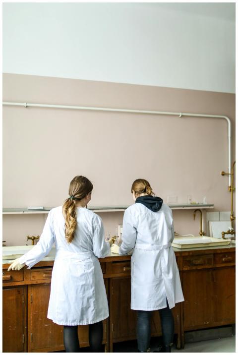 Two women in lab coats engaged in a scientific tas