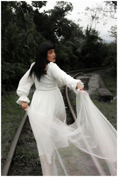 A woman in flowing white dress walks enchantingly