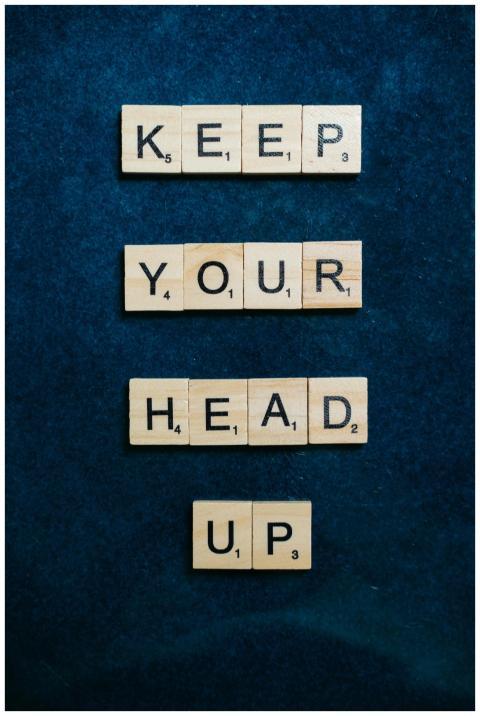 Scrabble tiles spelling 'Keep your head up' on a t