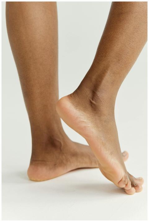 Detailed close-up of feet on a neutral background
