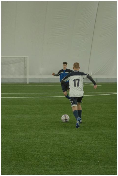 Two soccer players engaging in a competitive indoo