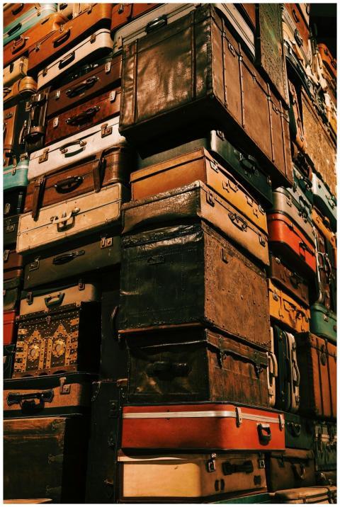 Towering pile of vintage suitcases representing tr