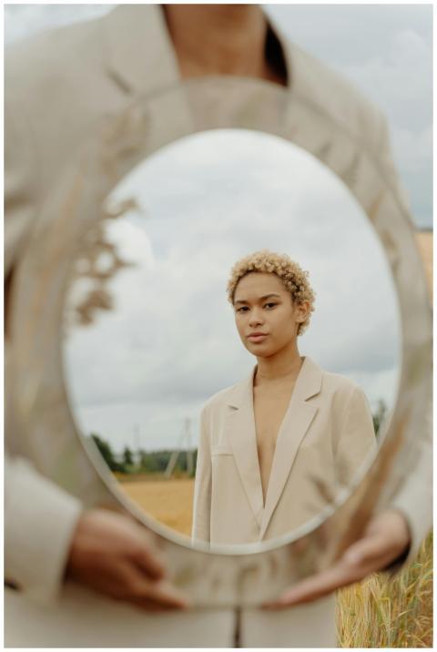 Stylish portrait using a mirror outdoors for a con
