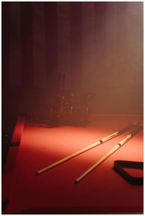 A moody still life of cue sticks on a billiard tab
