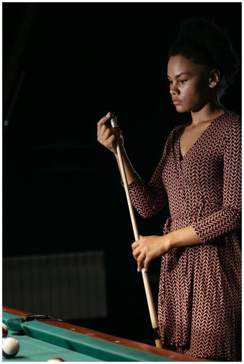 African American woman holding cue stick by billia