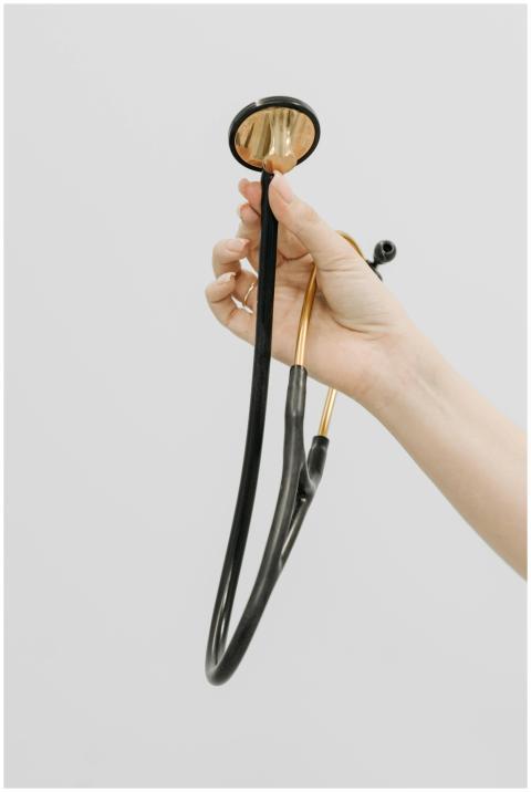Close-up of a hand holding a stethoscope against a