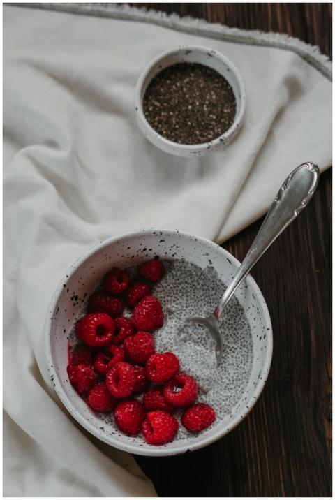 Chia pudding topped with juicy raspberries in a ru