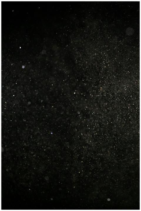 Fine dust particles floating in the dark, creating