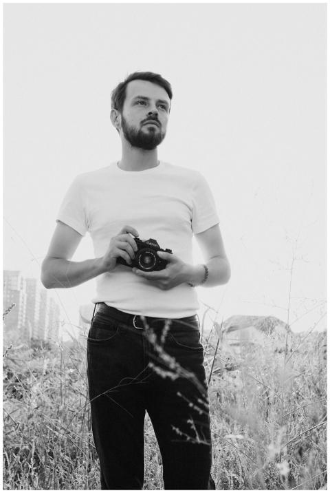 Artistic portrait of a bearded man with a camera i