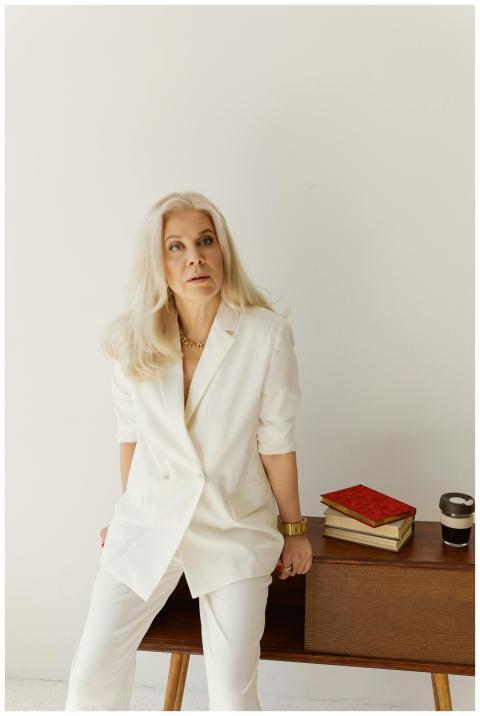 Stylish senior woman in business attire sitting on