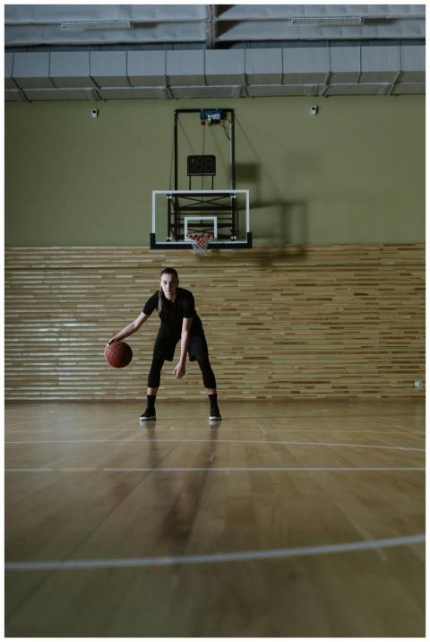 Woman dribbles basketball on indoor court. Perfect