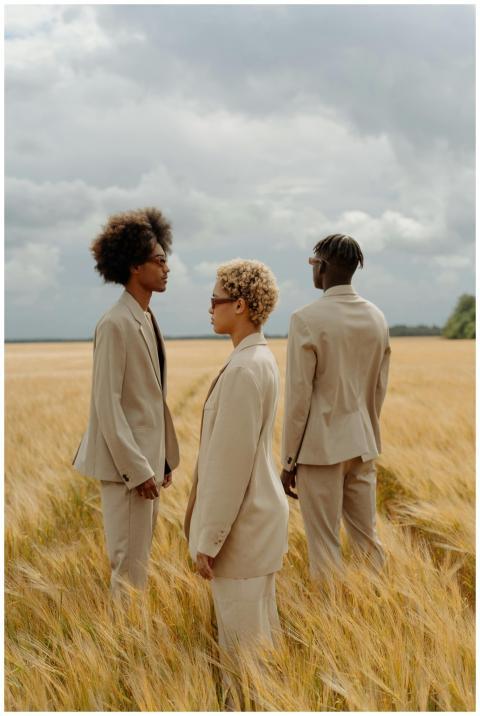 Three fashionable individuals in beige suits stand