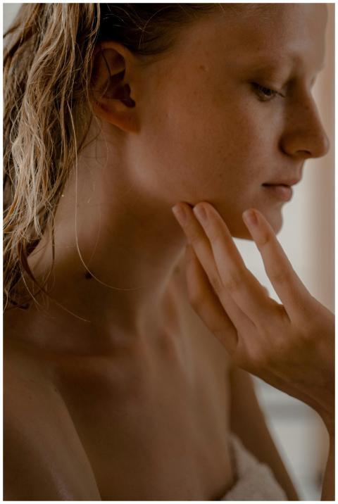 Close-up of a serene woman with long wet hair, emb