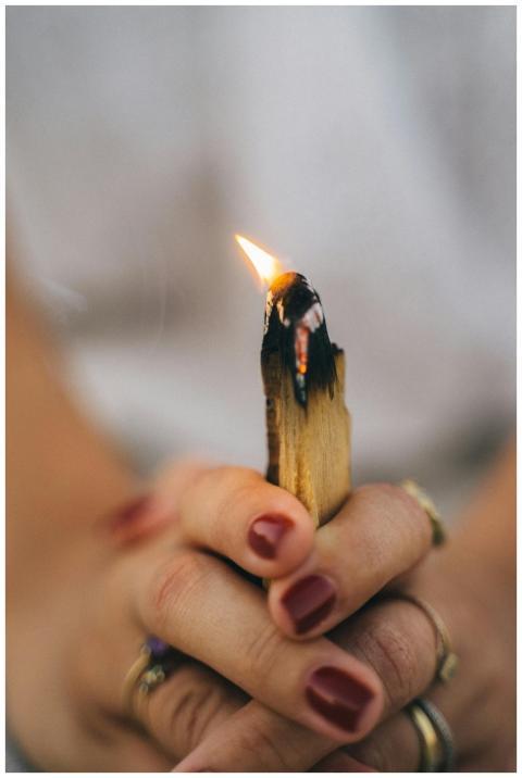 Close-up of a woman holding a lit Palo Santo stick