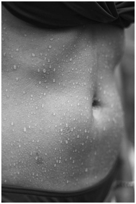 Black and white close-up of a torso with water dro