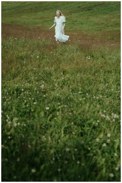 A serene scene of a woman in a white dress walking