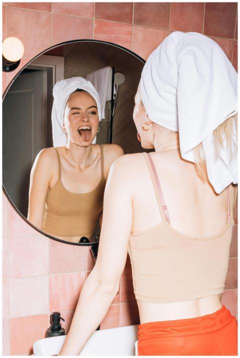 A young woman with a towel on her head makes a fun