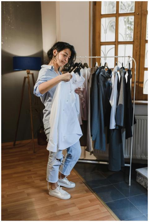 A woman browsing clothes on a rack in a stylish, w